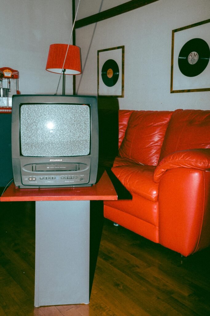 Vintage-themed room with a classic TV, red couch, and vinyl records.