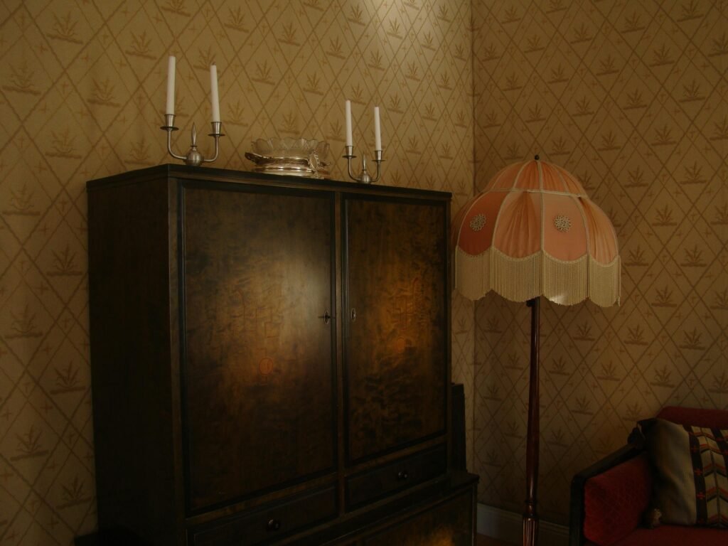Charming vintage room with an antique wooden cabinet and a classic standing lamp in a cozy setting.