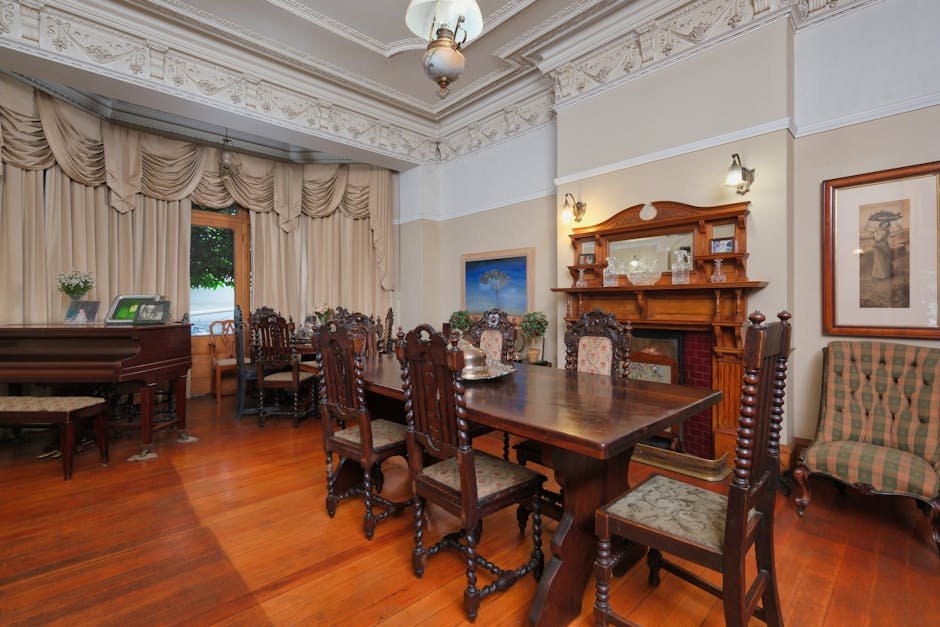 Victorian-style dining room table with ornate furniture, fireplace, and grand piano.