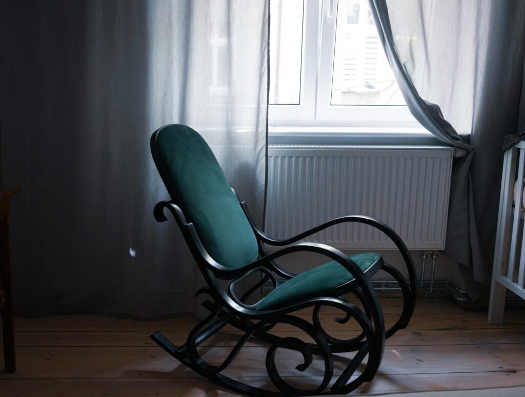 stylish green rocking chair by a window.
