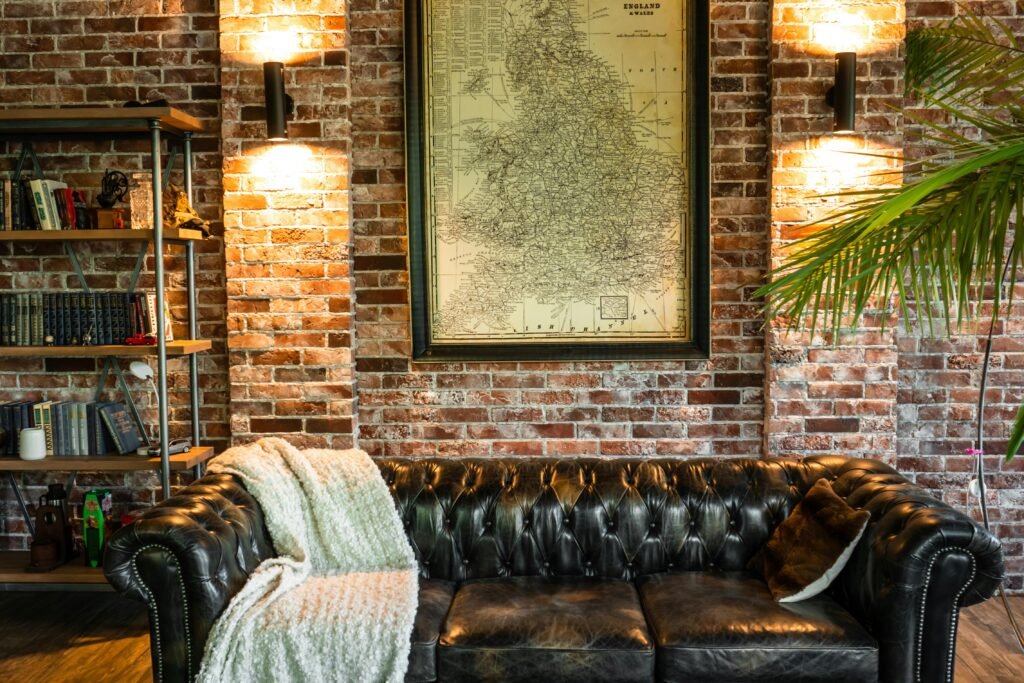 vintage leather sofa against a brick wall and map decor.