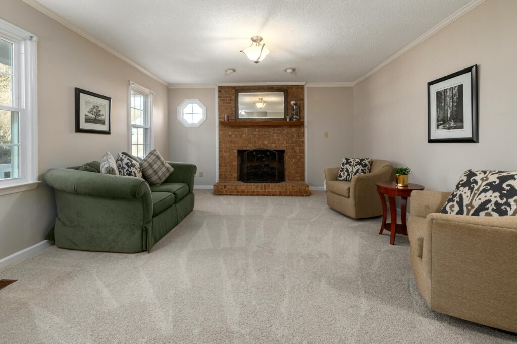 living room featuring a stylish fireplace, upholstery cleaning sofas