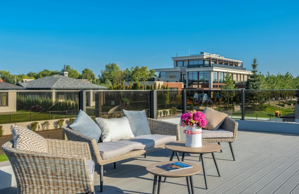 Outdoor terrace with seating and view of modern buildings under clear sky.