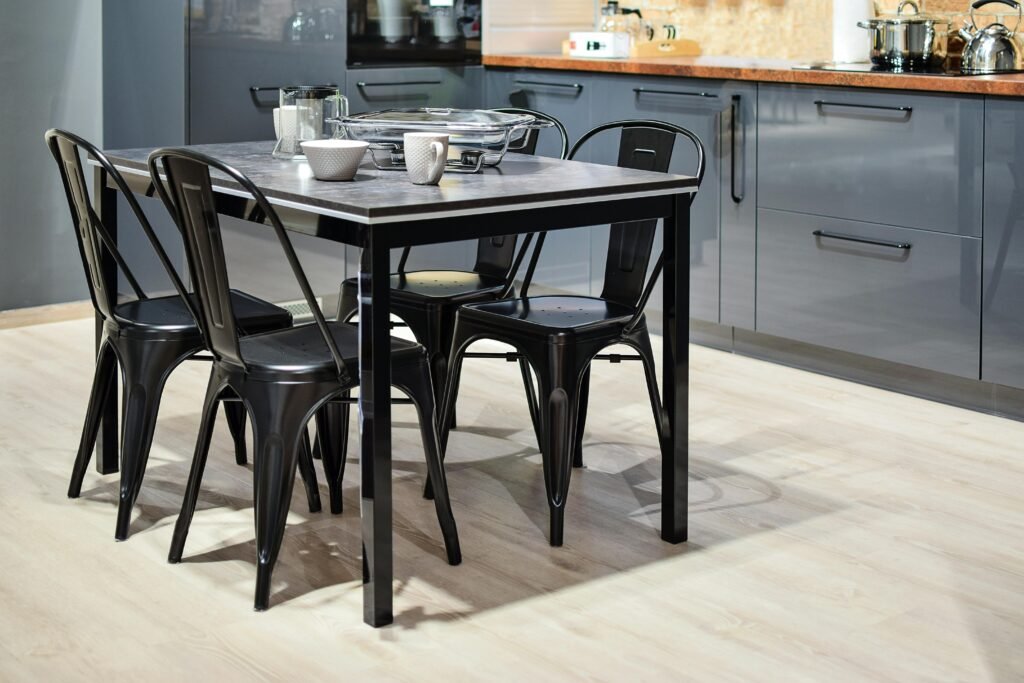 black metal dining table with chairs and sleek cabinetry.